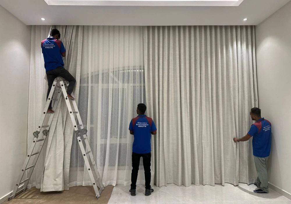 Workers hanging drapes during curtain installation