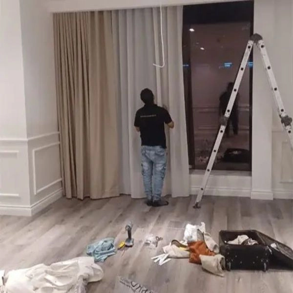 Technician completing villa bedroom curtain installation