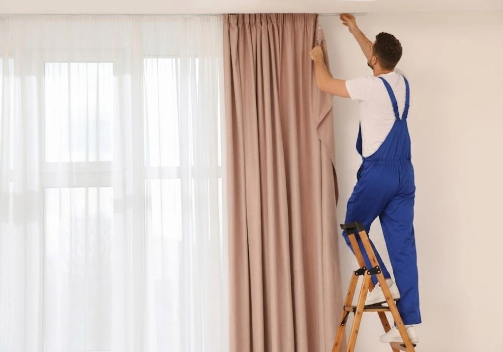 Technician adjusting track for curtain installation