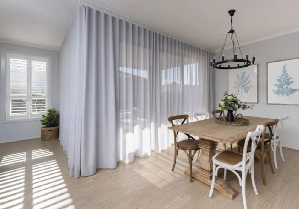 White sheer curtains partition wooden dining room