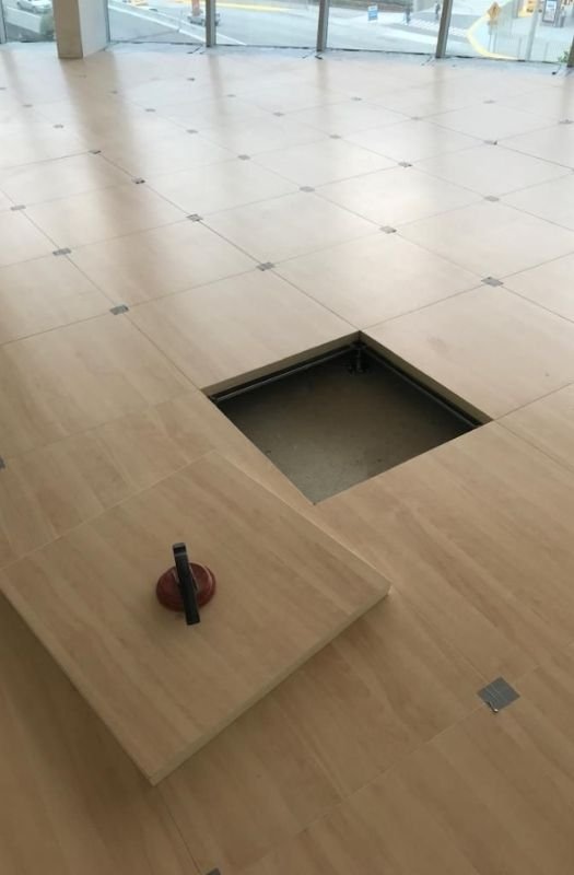 Raised access floor tile with suction lifter