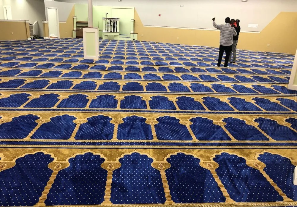 Blue mosque carpet rolls with arched prayer patterns