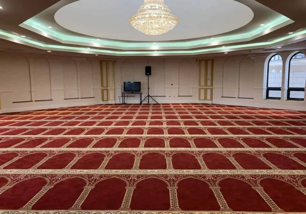 Red and gold patterned mosque carpet in grand hall